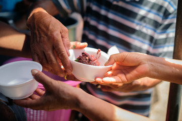 Homeless people pick up charity food from the food donors in society : The concept of the beggar problem on earth : The Hand of the Beggars receives charity food from fellow human beings