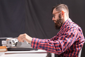 people, writer and hipster concept - young stylish writer working on typewriter