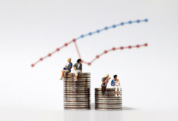 Miniature women sitting on a pile of coins of different heights. The concept of women's childbirth...