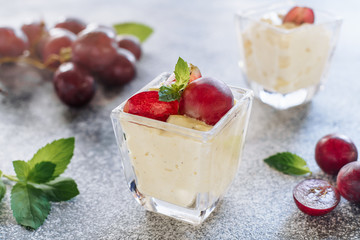 Panakota Sweet Grape Dessert Classic Refreshment. Delicious Vanilla Cooked Cream Yogurt with Fruit Thickened with Gelatin and Molded Decorated Vine Green Leaves. Jelly Panna Cotta Closeup Photo