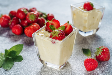 Strawberry Panakota Italian Cold Sweet Dessert. Traditional Delicious Dish Cooked Cream Yogurt with Ripe Red Berries Thickened with Gelatin and Molded Decorated Green Leaves. Panna Cotta Closeup Photo