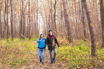 People, hike, tourism and nature concept - Couple tourist hiking in autumn forest