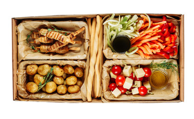 Delicious Health Meal Carton Box Isolated Delivery. Fried Potato and Grill Meat, Pepper, Carrot and Celery, Tomato with Emmental with Sauce and Breadstick in Package on White Background Top View