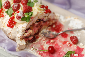 Delicate meringue pie with cherries, red currants and raspberries with mint leaves, close-up
