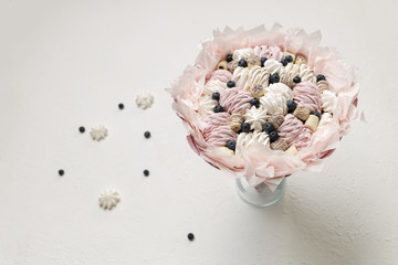Bouquet of sweets stands in a glass vase on a white background, copy space