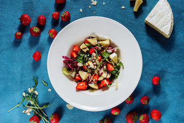 Salad with Brie Cheese and Strawberry Top View. Healthy Delicious Meal Dairy Product Camembert, Red Ripe Berry and Lettuce Green Leaves Seasoned with Balsamic Vinegar in White Plate
