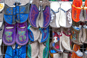 Fototapeta premium Handmade oriental slippers made of felt with a national ornament closeup. Market. Travel. Kyrgyzstan