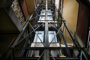Antique elevator shaft with stairs that surround it