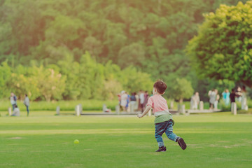 Obraz premium Kid enjoy to playing with little ball on green field