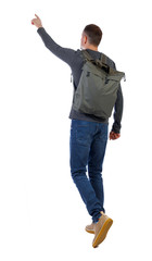 Fototapeta premium Back view of a walking man with a bag pointing his hand up.