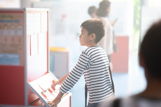 Student boy reading description of science project at museam
