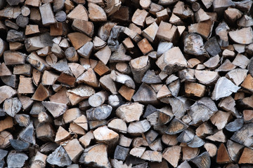 a pile of firewood. stack of dried wood piece. Preparation for the heating, cooking and light.