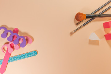 An assortment of beauty products on a pink surface