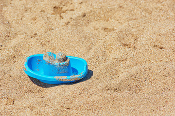 Fototapeta na wymiar Childrens toy boat on sandy beach.