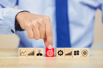 Hand of busines hold a target with arrow,stacking wooden blocks into steps,Concept of business...