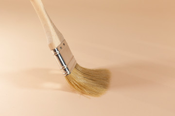 A brown paintbrush is being used to paint a surface