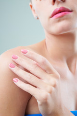 Obraz na płótnie Canvas Close-up image of woman applying moisturizing body lotion on her shoulder