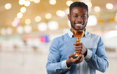 Happy business black man holding a trophy