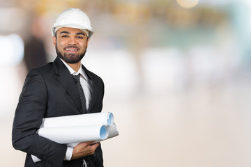 Confident smiling portrait of black architect holding plans isolated in studio