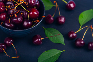 Ripe sweet cherry in a black bowl
