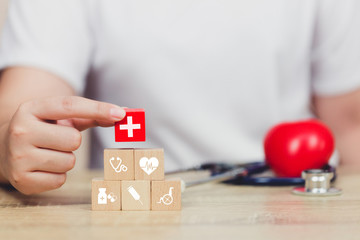 Fototapeta premium Health Insurance Concept,hand arranging wood block stacking with icon healthcare medical.