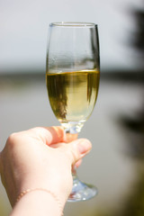 white wine swiveling in a glass, river in the background