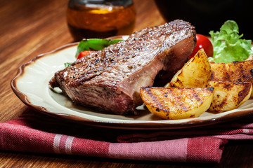 Portions of grilled beef steak with grilled potatoes and paprika
