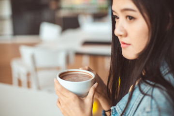 Attractive Asian woman drinking coffee.cheerful girl drinking coffee or tea in morning