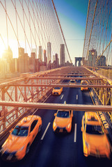 Naklejka premium Cubs speeding at sunset on Brooklyn Bridge, Manhattan. One of the most iconic bridges in the world, New York City