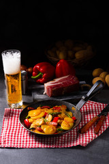 Fried potatoes with smoked bacon, green asparagus and paprika.
