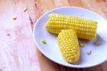 Boiled corn cobs isolated on wooden background