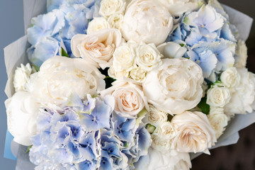 White peonies and blue hydrangea. Beautiful bouquet of mixed flowers in woman hand. Floral shop concept . Handsome fresh bouquet. Flowers delivery