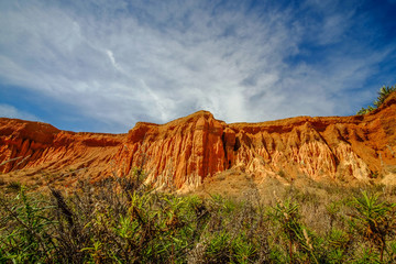 Red sandstone cliffs on the beach the Praia da Rocha Baixinha Nascente. Region Faro, Algarve, Portugal.