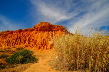 Red sandstone cliffs on the beach the Praia da Rocha Baixinha Nascente. Region Faro, Algarve, Portugal.
