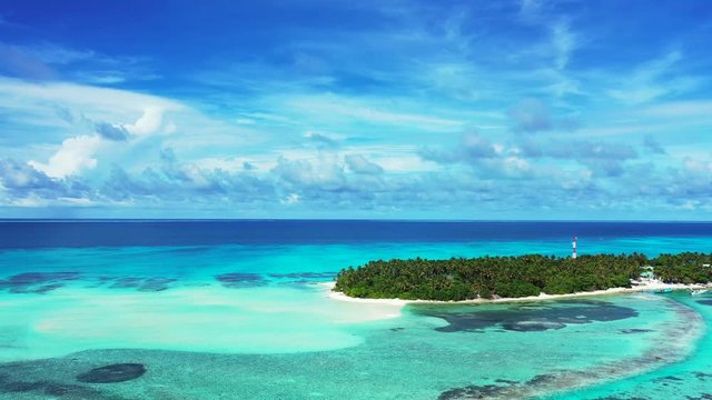 Aerial view of a tropical island with a forest and village on it. Surrounded by the turquoise and blue sea in the Gulf of Thailand. Reefs in the water. dolly out, pan right