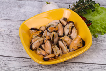Pickled mussels in the bowl served pepper, garlic and salad