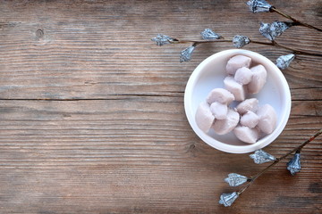 Purple Thai shortbread cookies (Kleeb Lamduan) on white plate, Thai dessert on aged wooden table background, have copy space for put text