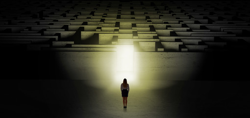 Woman getting ready to enter the dark labyrinth with illuminated door
