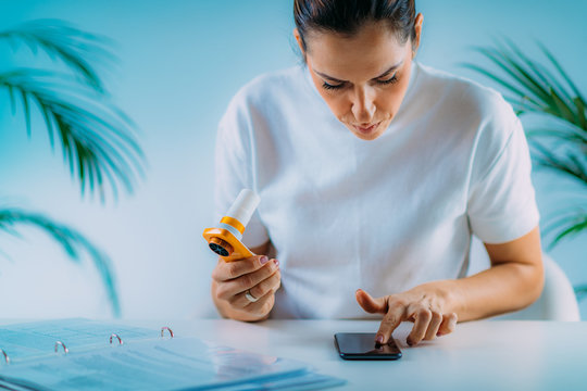 Woman Monitoring Respiratory Illness with Spirometer and Smart Phone