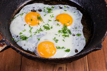 Fried eggs with unbroken yolks on frying pan close-up