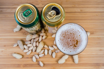 Top view of beer in glass and two beer cans
