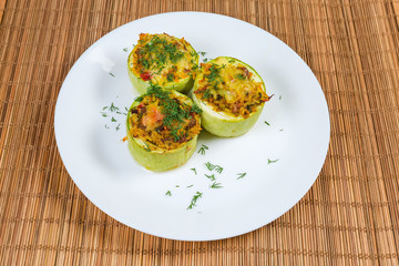 Baked stuffed pieces of vegetable marrow on dish