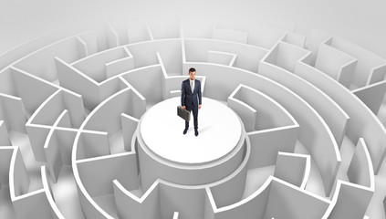 Businessman standing on the top a maze and looking through
