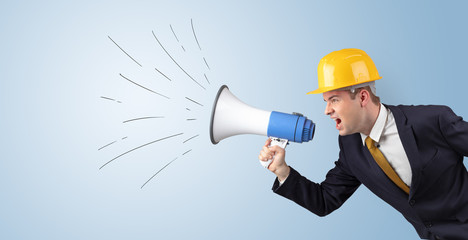 Fototapeta premium Young architect constructor yelling with megaphone and copyspace 