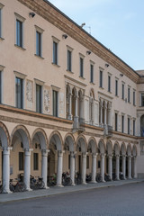 Fototapeta na wymiar bikes parked under coverd walkway of historical building, Crema, Italy