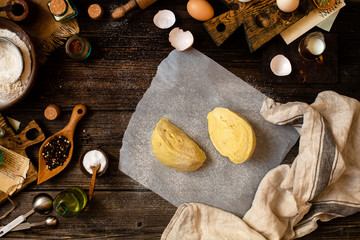 Overhead shot of homemade dough on baking paper on rustic table 