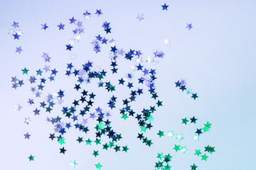 Holographic confetti stars on blue neon background