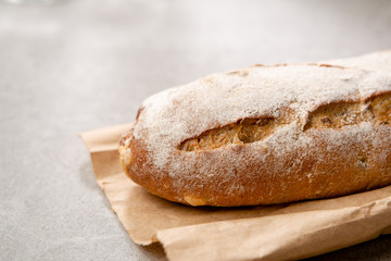 Loaf of brown bread on gray background