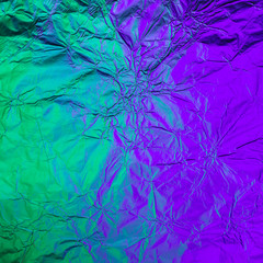 Purple green crumpled background made of illuminated foil. Trendy duotone texture