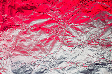 Red white metallic background made of neon lights foil. Trendy duotone texture